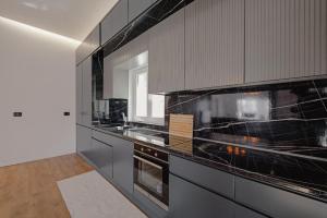a kitchen with black cabinets and a stove top oven at Vila Osmani in Ksamil