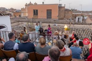 un grupo de personas sentadas en sillas frente de una multitud en Le Foglie Di Acanto, en Lucera