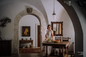 una donna in piedi in una stanza con un tavolo di Le Foglie Di Acanto a Lucera