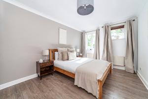 a white bedroom with a bed and a window at The Brixton Collection in London