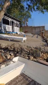 a stone wall with white benches in front of a building at AlmaVille Mamaia in Mamaia Nord
