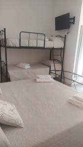 een slaapkamer met 2 stapelbedden en een flatscreen-tv bij Affittacamere Sole e Luna in Vatolla