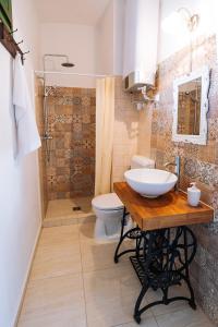 a bathroom with a sink and a toilet and a shower at Kőfejtő háza in Fertőrákos