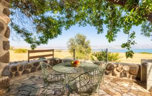 una mesa y sillas con un bol de fruta en el patio en Vered Hagalil Holiday Village Hotel, en Chorazim