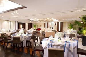 a banquet hall with white tables and chairs at Hotel Emisia Tokyo Tachikawa in Tachikawa