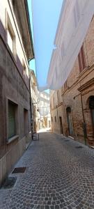 an empty street in an alley between two buildings at I Templari - Affittacamere in Castignano