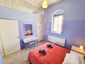 1 dormitorio con cama roja y escritorio en Village Charm with Pool Apartment at Skarinou, en Skarinou