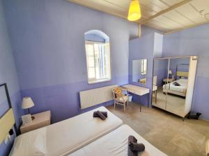 Habitación azul con 2 camas y espejo. en Village Charm with Pool Apartment at Skarinou, en Skarinou
