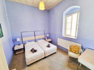 - une chambre bleue avec 2 lits et une chaise dans l'établissement Village Charm with Pool Apartment at Skarinou, à Skarinou