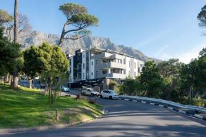 a street with a building on the side of a road at Deer Park Apartment CPT - With Sweeping Views in Cape Town