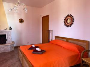 ein Schlafzimmer mit einem orangenen Bett mit einem ausgestopften Tier darauf in der Unterkunft A 5 MINUTI DA TRAPANI e FREE PARKING in Torre Nubia
