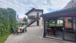 eine Terrasse mit Tischen und Stühlen und ein Gebäude in der Unterkunft Penzion a restaurace U Strnada in Klatovy