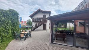 un patio con mesas y sillas y un edificio en Penzion a restaurace U Strnada, en Klatovy