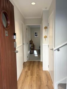 an empty hallway with a wooden door and a hallway with a hallway at Ultimate Location Luxury Retreat - 2 bedrooms 2 bathrooms in Mount Maunganui