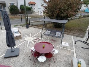 a table and chairs with a table and umbrella at Chambre privative avec salle d'eau in Chasseneuil