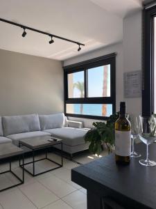 a living room with a bottle of wine on a table at Sea La Vie #1 - Luxury Seaview apartment in Paphos City