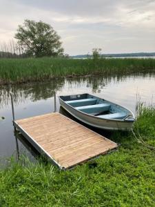 un bateau bleu à côté d'un quai sur un lac dans l'établissement Luckin Retreat with Large Backyard, à Trenton