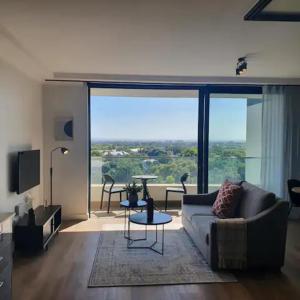 a living room with a couch and a table at Newlands Peak - Spacious one-bed apartment in Cape Town