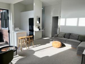 uma sala de estar com um sofá e uma mesa em Ultimate Location Luxury Retreat - 2 bedrooms 2 bathrooms em Mount Maunganui