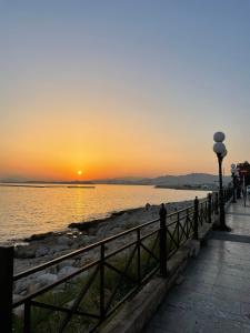 una puesta de sol sobre el agua con un muelle en Piraiki Coastal Accommodation en Piraeus