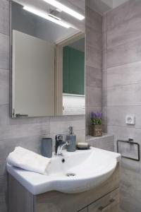 bagno con lavandino bianco e specchio di Piraiki Coastal Accommodation a Pireo