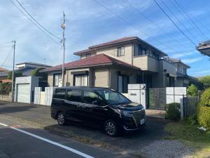 宮崎市にあるゲストハウス宮崎 guesthouse miyazaki バックパッカー向け個室旅人宿 P有宮崎駅1km喫煙者不可の家の前に停められた黒車