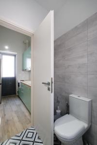 uma casa de banho com um WC branco num quarto em Piraiki Coastal Accommodation em Pireu