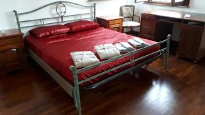科里亞諾的住宿－Villa con Piscina，卧室内的一张带红色床单和白色枕头的床