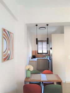 a dining room with two tables and chairs and a kitchen at Orfhl Studio in Missolonghi