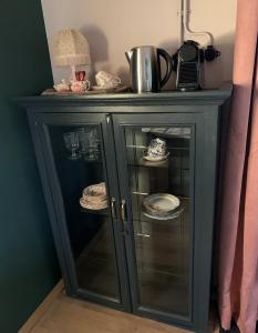 une armoire bleue avec des assiettes et de la vaisselle dans l'établissement Bed and Breakfast Bakrust, met privé sauna Putten, à Putten