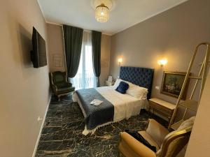 a hotel room with a bed and a chair at Prestige Suite Via Romagnoli in Sirmione