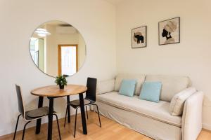 a living room with a couch and a table and a mirror at Holidays2Malaga Victoria 40 Quiet & Central in Málaga