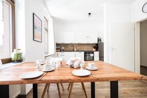 una mesa de comedor con platos blancos. en Ko-Living Space am Neuen Theater - einzigartige Unterkünfte mit Stil, en Halle an der Saale