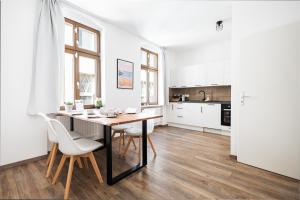a kitchen with a table and chairs in a room at Apartments am Neuen Theater - Altstadt - Zentral - Küche - Wifi - Powered by Ko-Living in Halle an der Saale