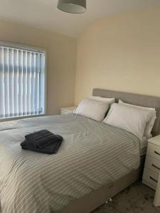 a bedroom with a bed with a hat on it at Lovely 3 bedroom house with off street parking in Thornton