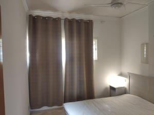 1 dormitorio con cama y cortina marrón en l4 en Santiponce