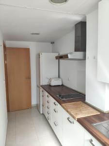 a kitchen with white cabinets and a refrigerator at l4 in Santiponce