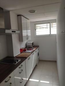 a kitchen with white appliances and a window at l4 in Santiponce