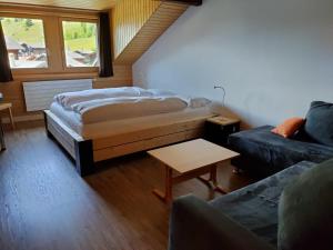 a bedroom with a bed and a couch and a table at Hotel Furka in Oberwald