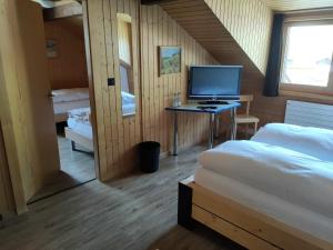 a room with two beds and a computer on a desk at Hotel Furka in Oberwald