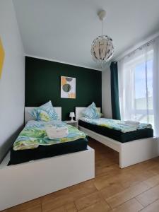 a bedroom with two beds and a chandelier at ApartHome K8 Centrum Sulęcin in Sulęcin