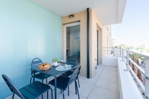 a balcony with a blue table and chairs at Appartement Neuf 4 étoiles - Sunset Lodge, Narbonne Plage in Narbonne