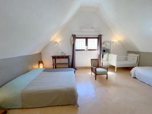 a attic bedroom with a large bed and a chair at Villa Isabella in Trou dʼ Eau Douce
