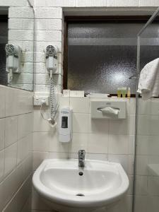 a bathroom with a sink and a phone on the wall at Marco Polo Motor Inn Sydney in Sydney