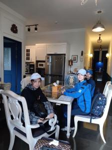 un grupo de personas sentadas en una mesa en una cocina en The Castle Stay, en Chuncheon