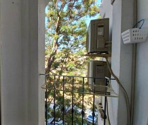 - un balcon avec un téléphone offrant une vue sur un arbre dans l'établissement Bonito apartamento en centro, à Malaga
