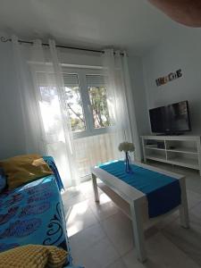 - un salon avec une table et une télévision dans l'établissement Bonito apartamento en centro, à Malaga