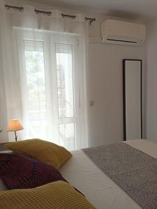 - une chambre avec un lit et une grande fenêtre dans l'établissement Bonito apartamento en centro, à Malaga