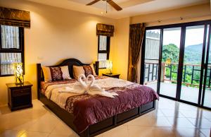 ein Schlafzimmer mit einem Bett mit zwei Handtüchern darauf in der Unterkunft Baan Chom View Kamala - SHA Plus in Kamala Beach