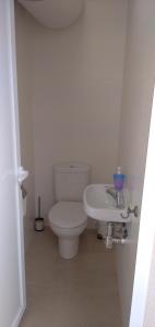 a white bathroom with a toilet and a sink at La Casita del pescador in Cabo de Palos
